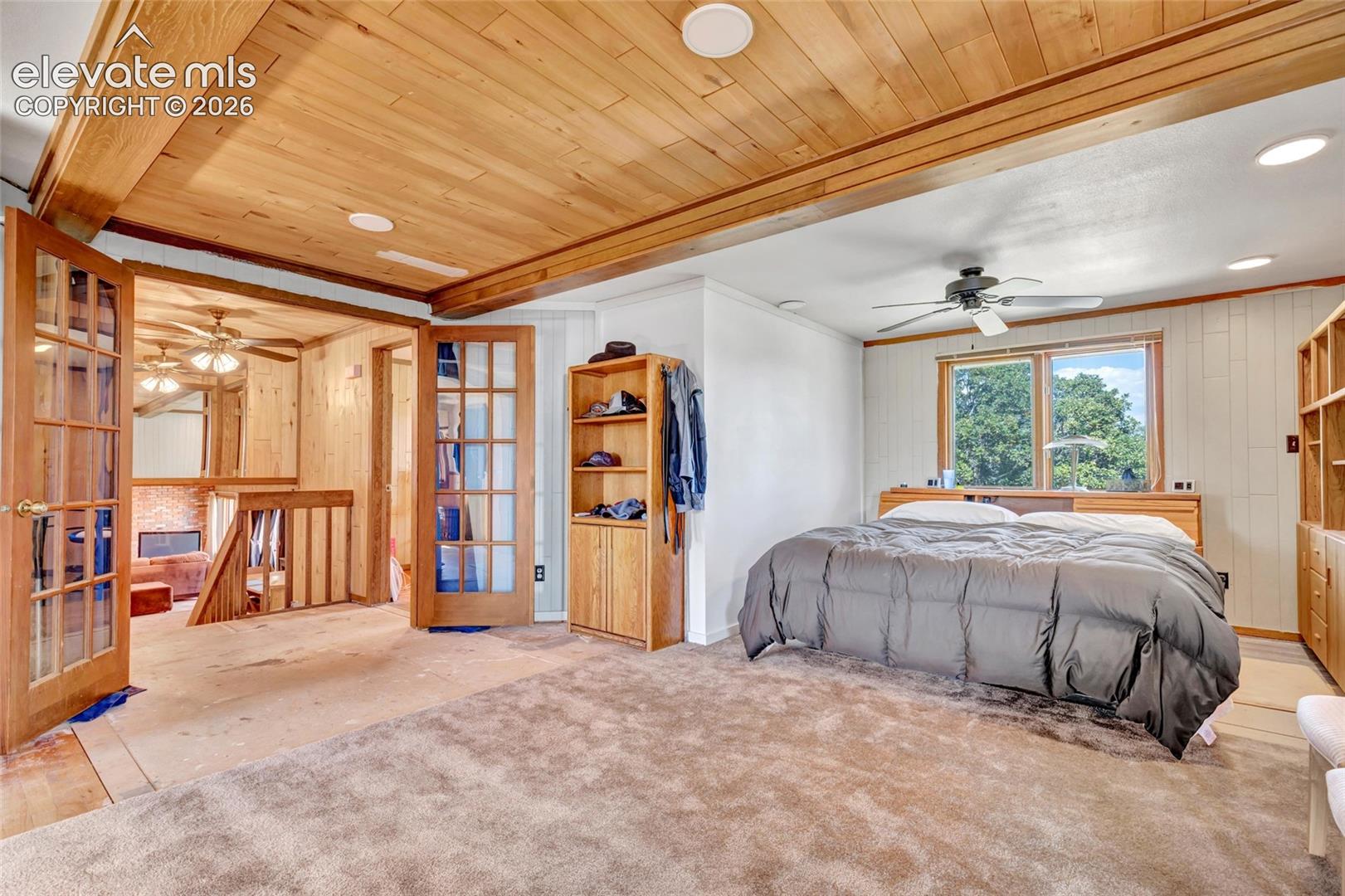 Wood-paneled ceilings, recessed lighting, and a ceiling fan