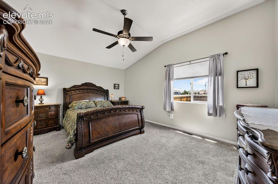 MB Carpeted room featuring a vaulted ceiling and a ceiling fan with integrated lighting