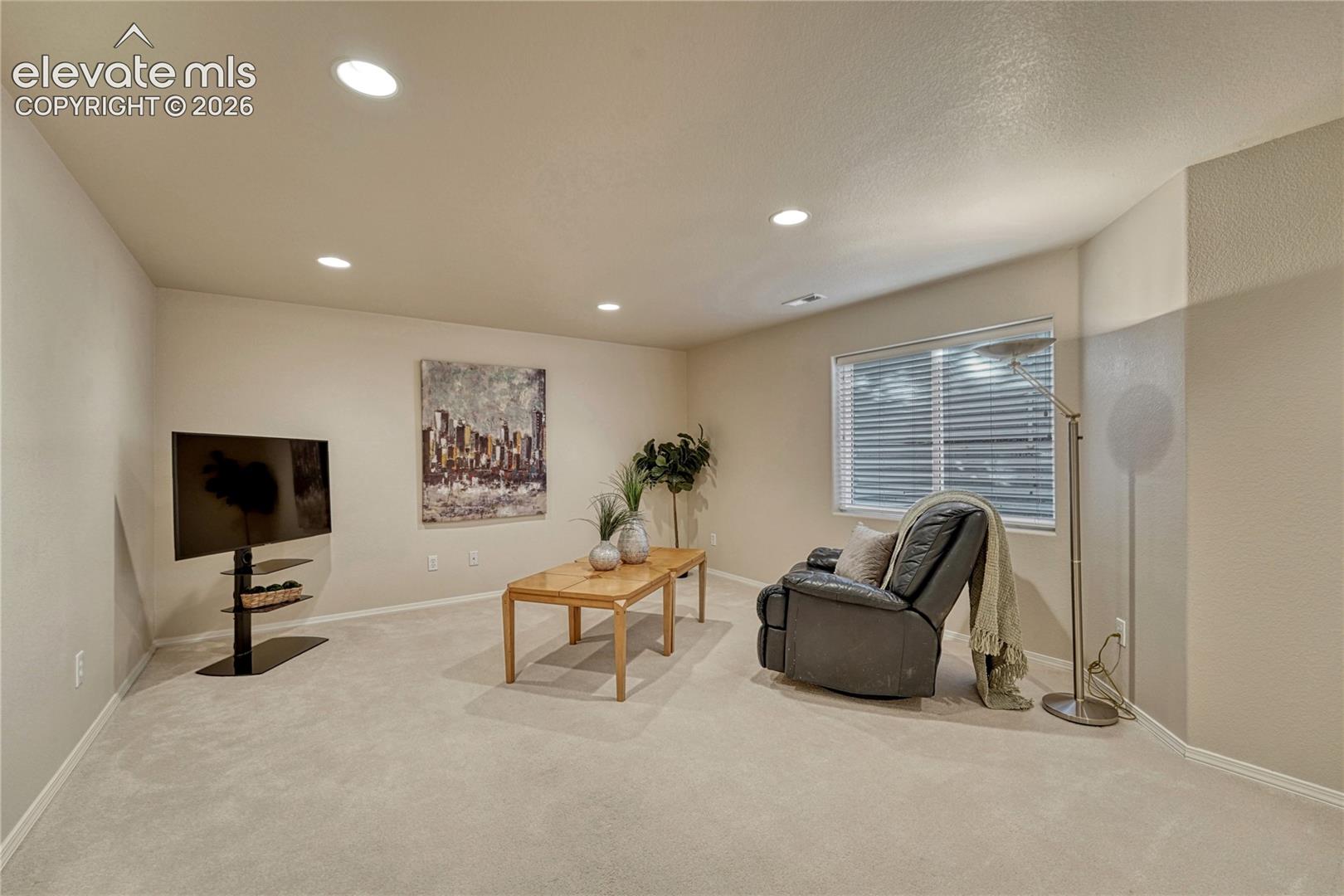 High 8-foot ceilings and bright recessed lighting make the basement family room feel open, warm, and inviting
