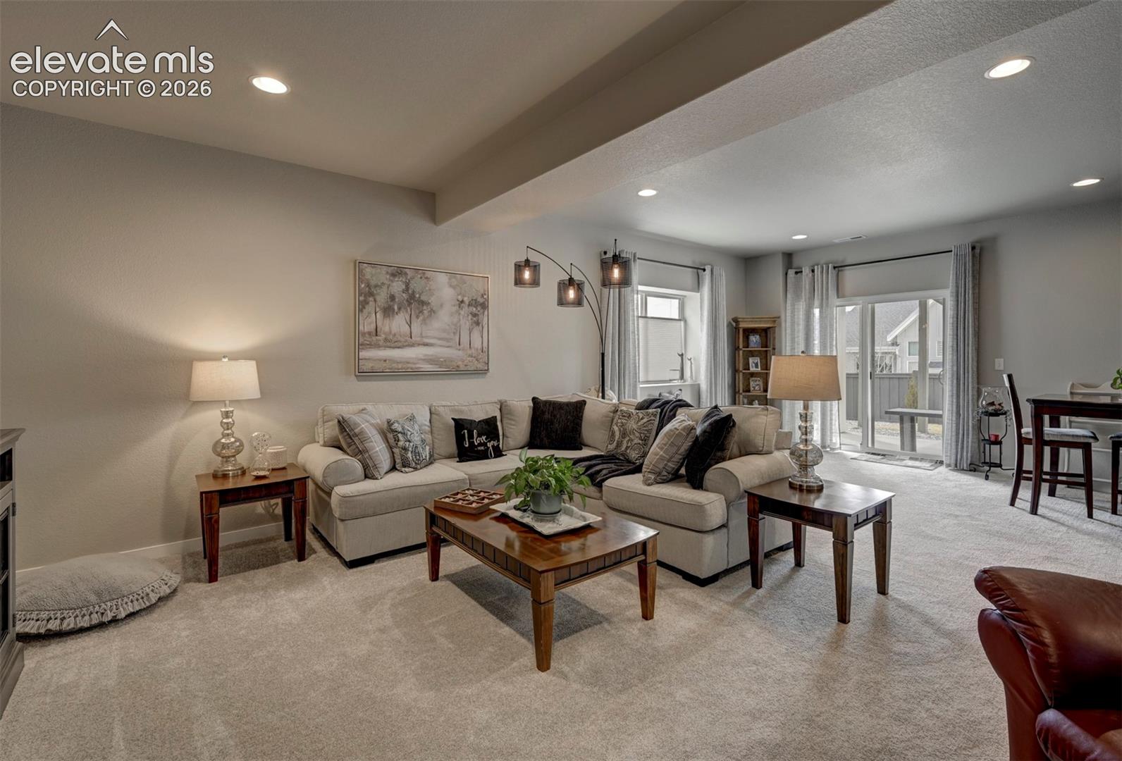 Recessed lighting, light-colored carpeting, and a glass-paneled sliding door