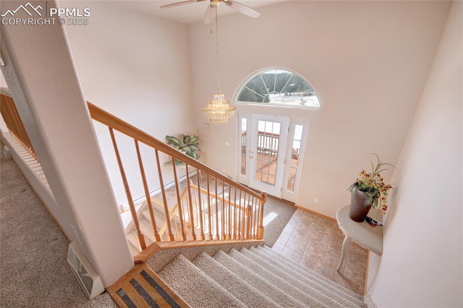 Foyer with ceiling fan with notable chandelier