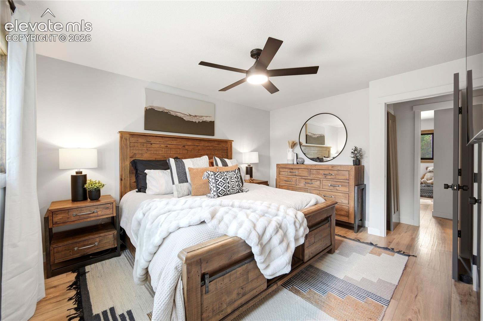 Wood-finish flooring, ceiling fan with integrated lighting, and neutral wall tones