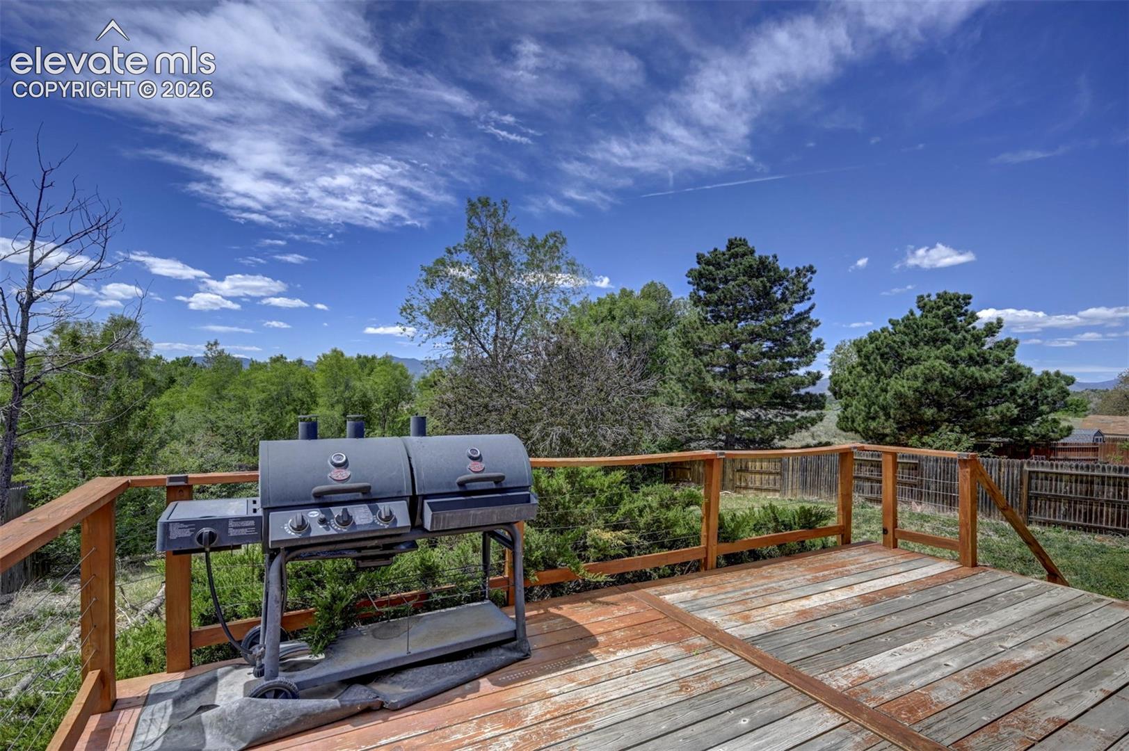Spacious outdoor wood deck with a natural finish, featuring wood railings