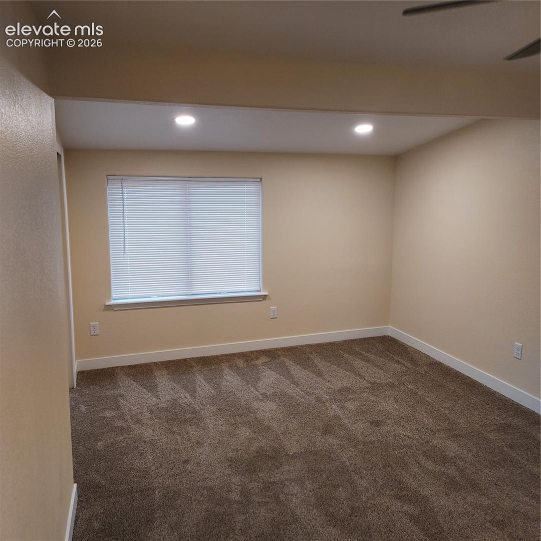 Bedroom room featuring carpeted flooring, recessed lighting, and a window with horizontal blinds