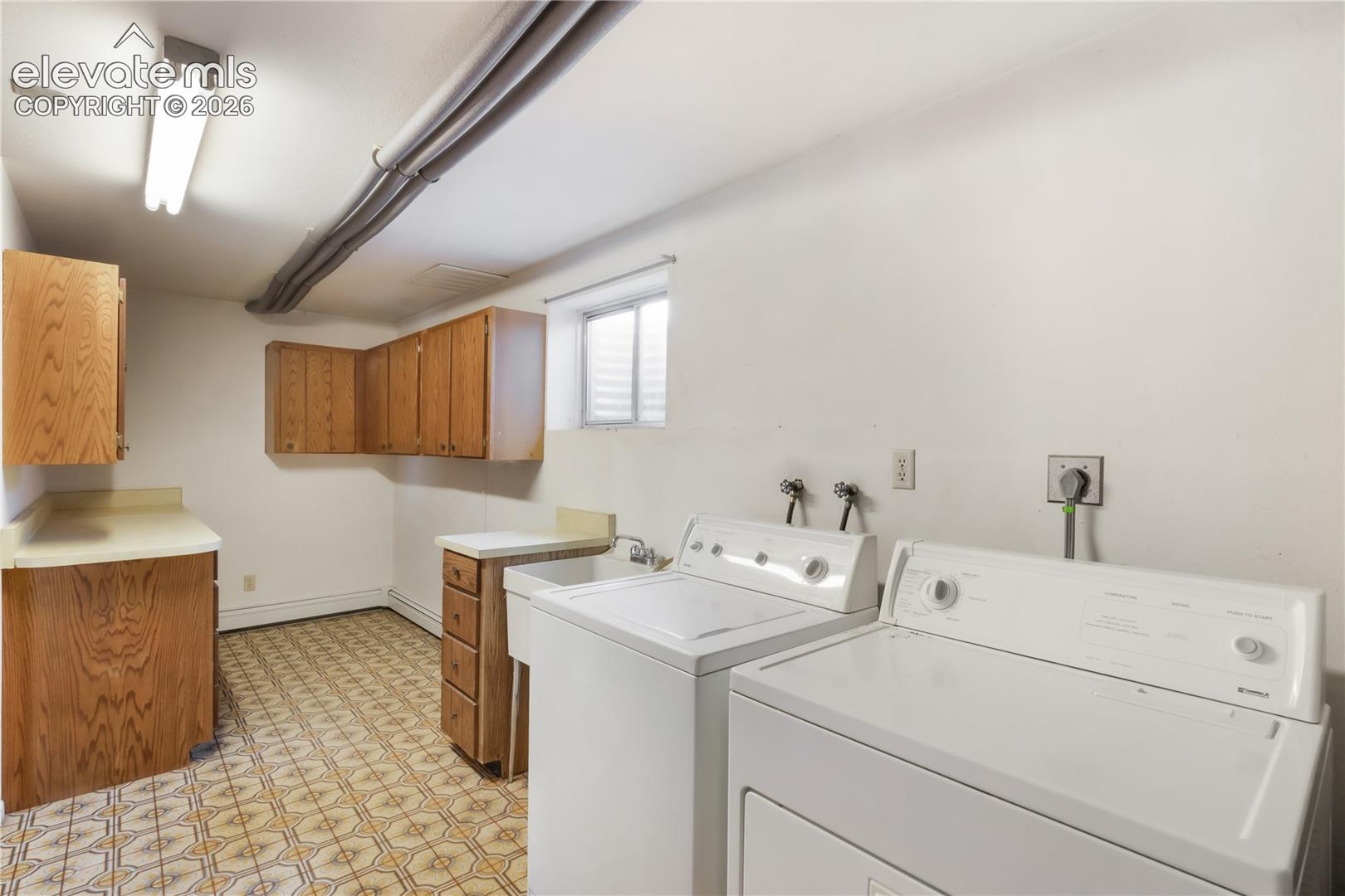 Laundry room in basement with tons of storage