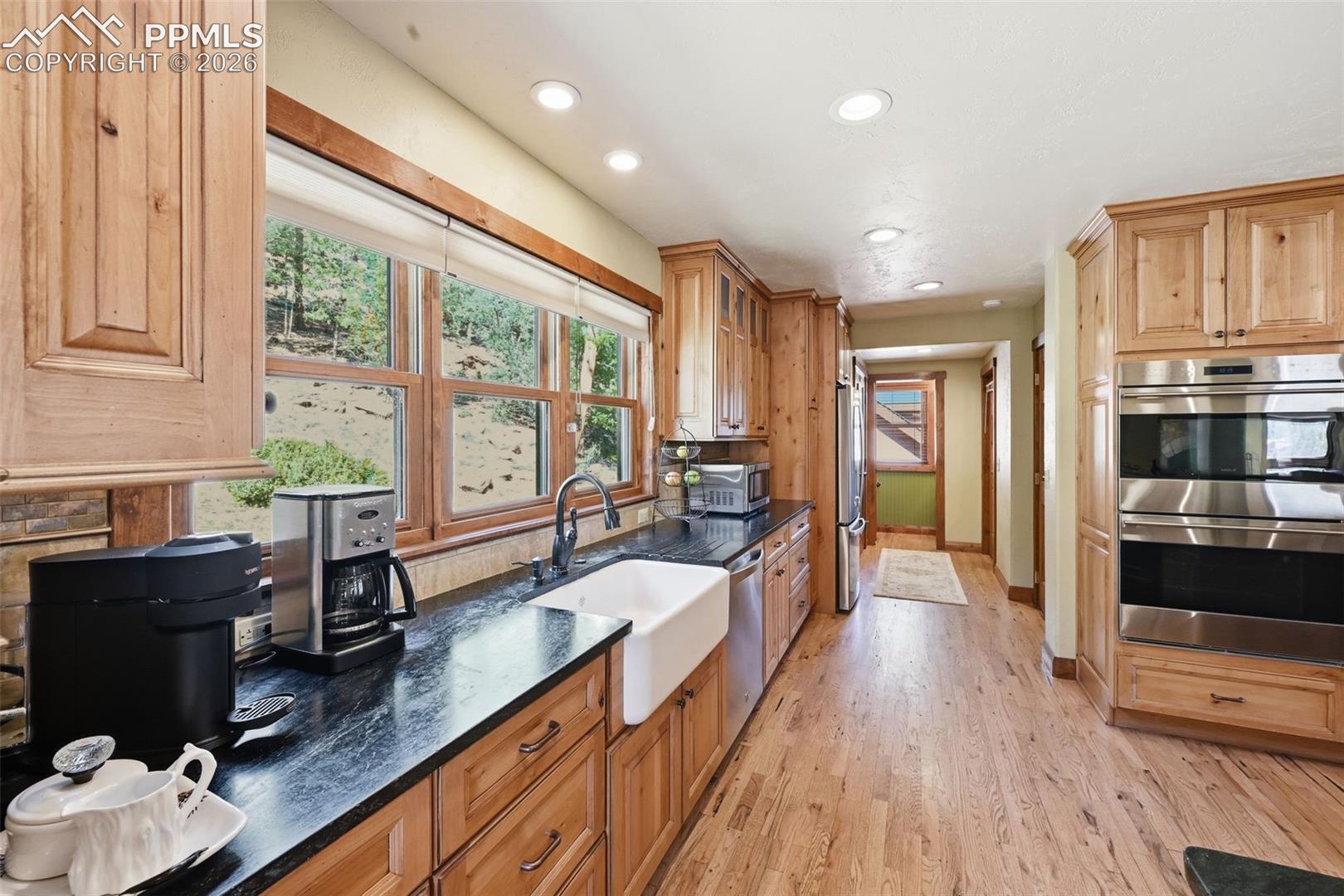 Farmhouse sink is accompanied by picturesque windows, so you can get lost in nature's beauty, even while preparing dinner. 