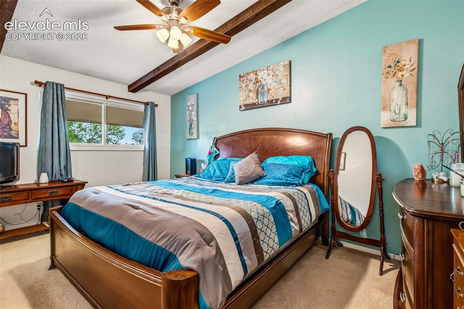 Exposed wood-finish ceiling beams, ceiling fan with integrated lighting, and horizontal sliding window