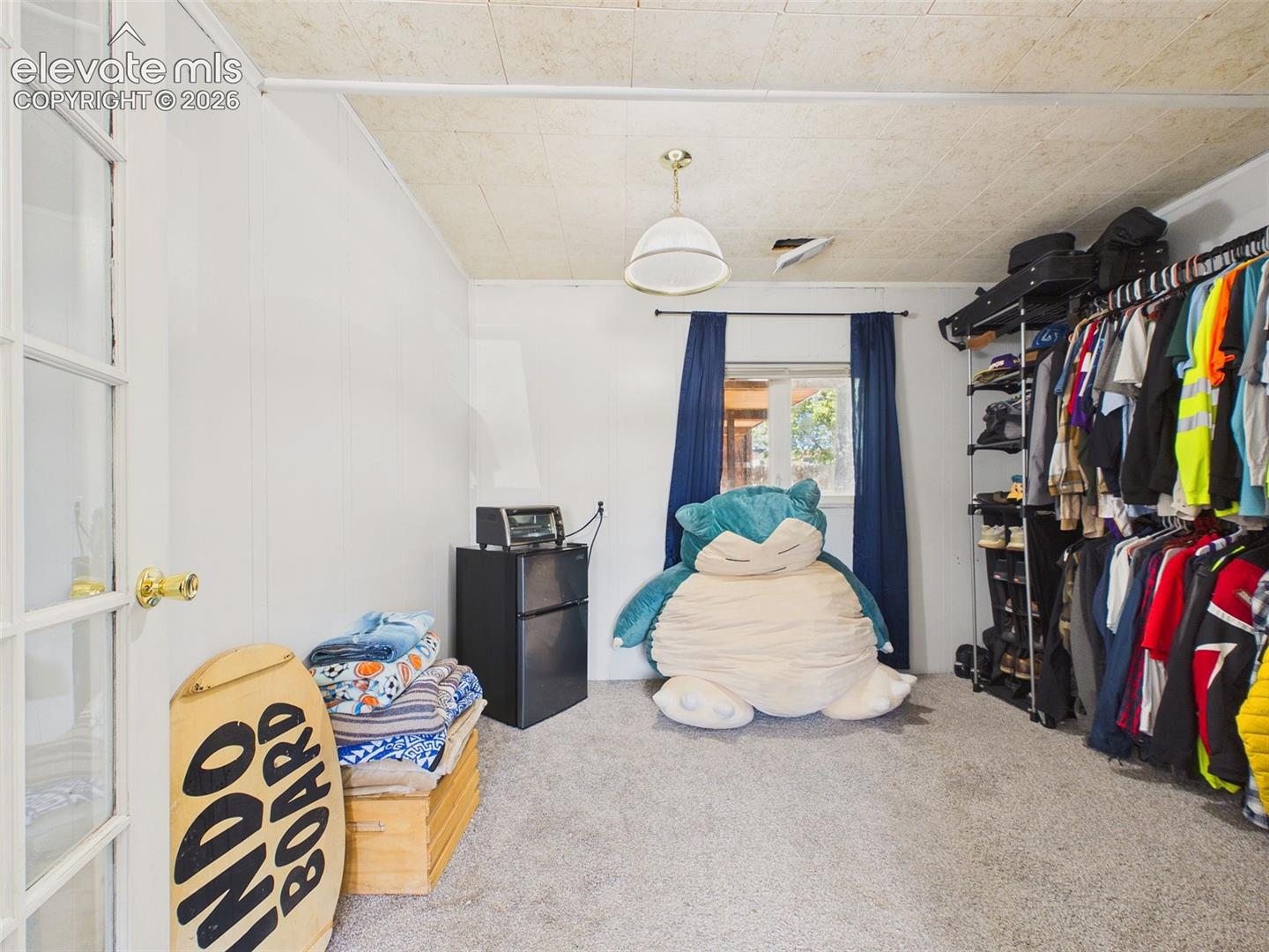 Flexible adjoining space offers extensive open clothing storage, carpeting, a window for natural light, and convenient connection to the bedroom.