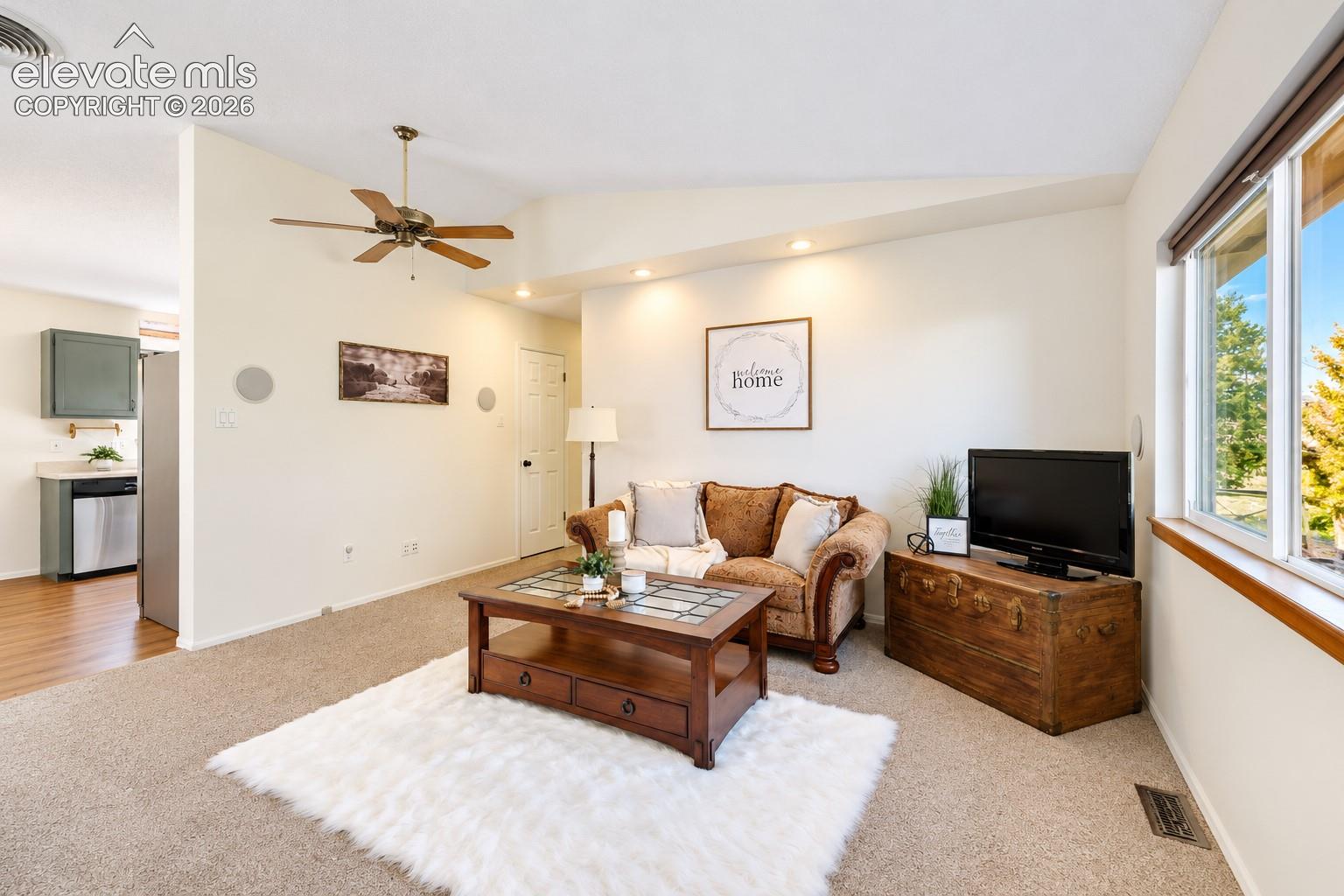 Living area featuring vaulted ceilings, recessed lighting, and a ceiling fan