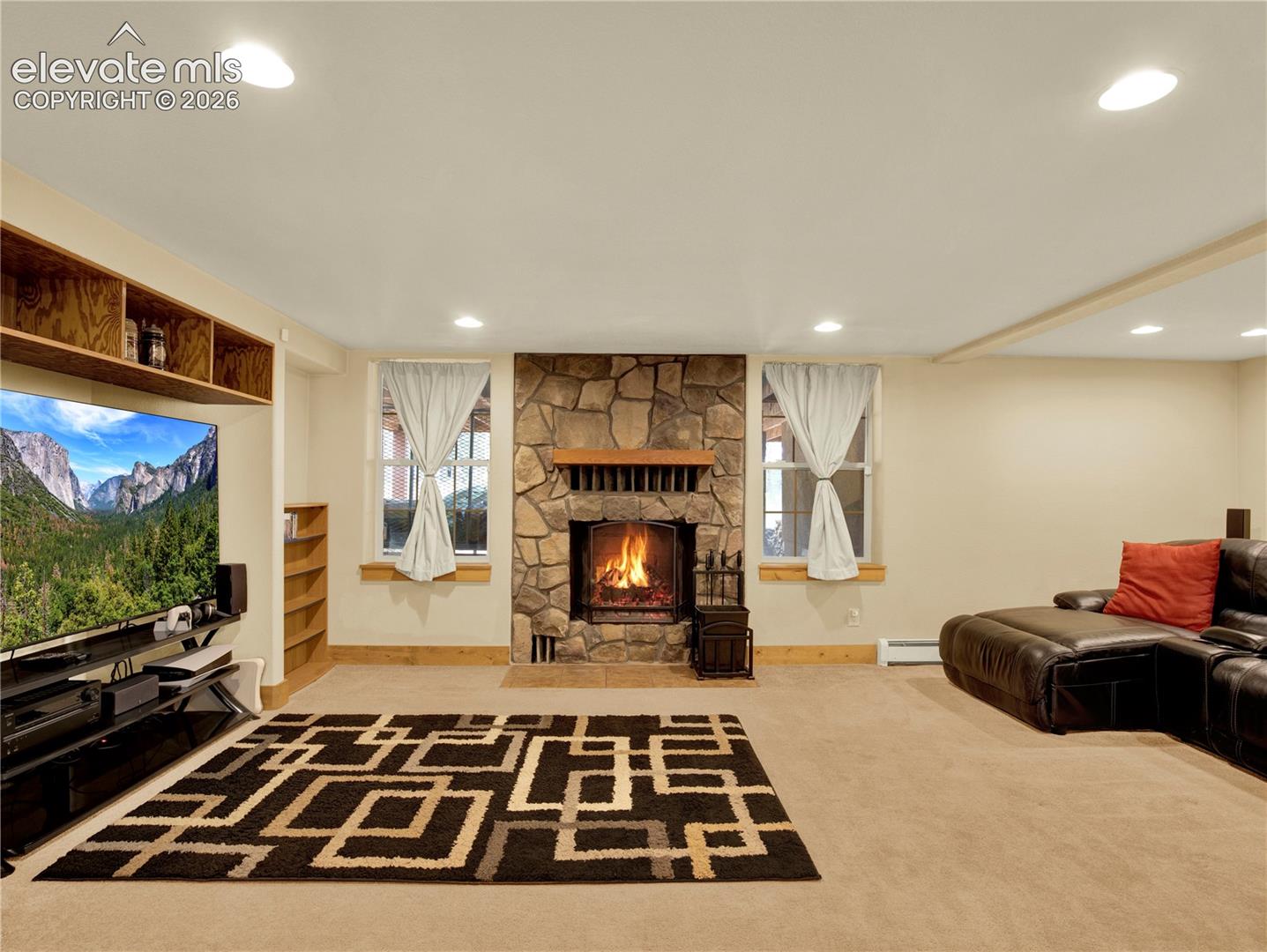 Family room space beyond the bar area for lounging in front of the TV and wood burning fireplace