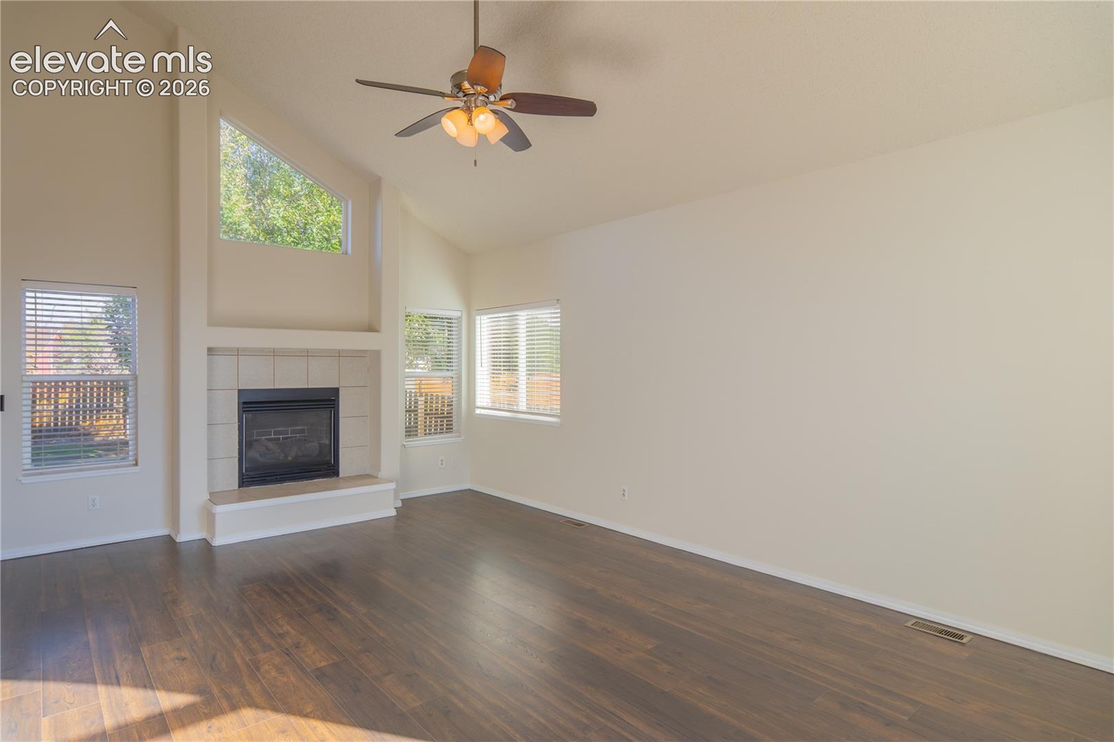 Soaring vaulted ceilings, a gas fireplace, and abundant natural light create an impressive living space.