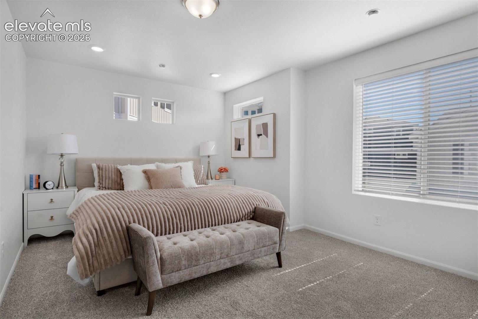 Recessed lighting, large window with blinds, two high-set transom windows, and neutral carpeting
*photos of a model home*