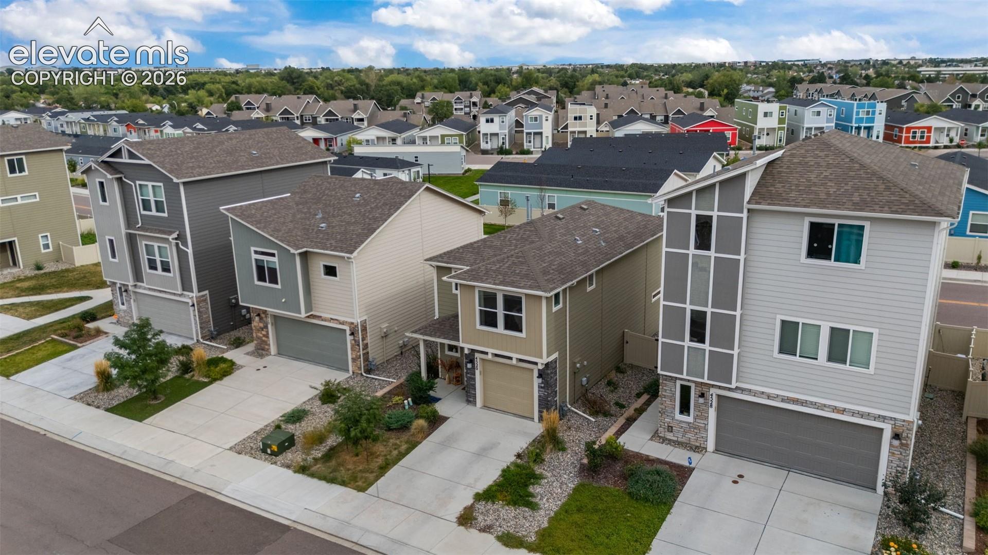 Modern architectural design featuring multi-story residences with attached garages and paved driveways