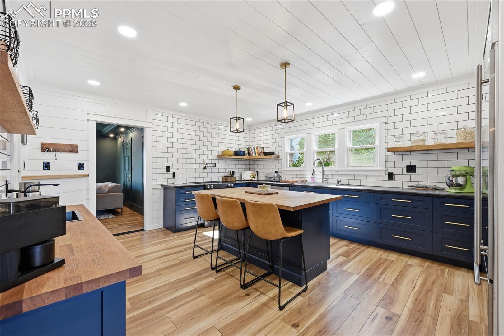 Beautifully remodeled kitchen hosts bold cabinets, soothing LVP floors, and and clean white textures. 