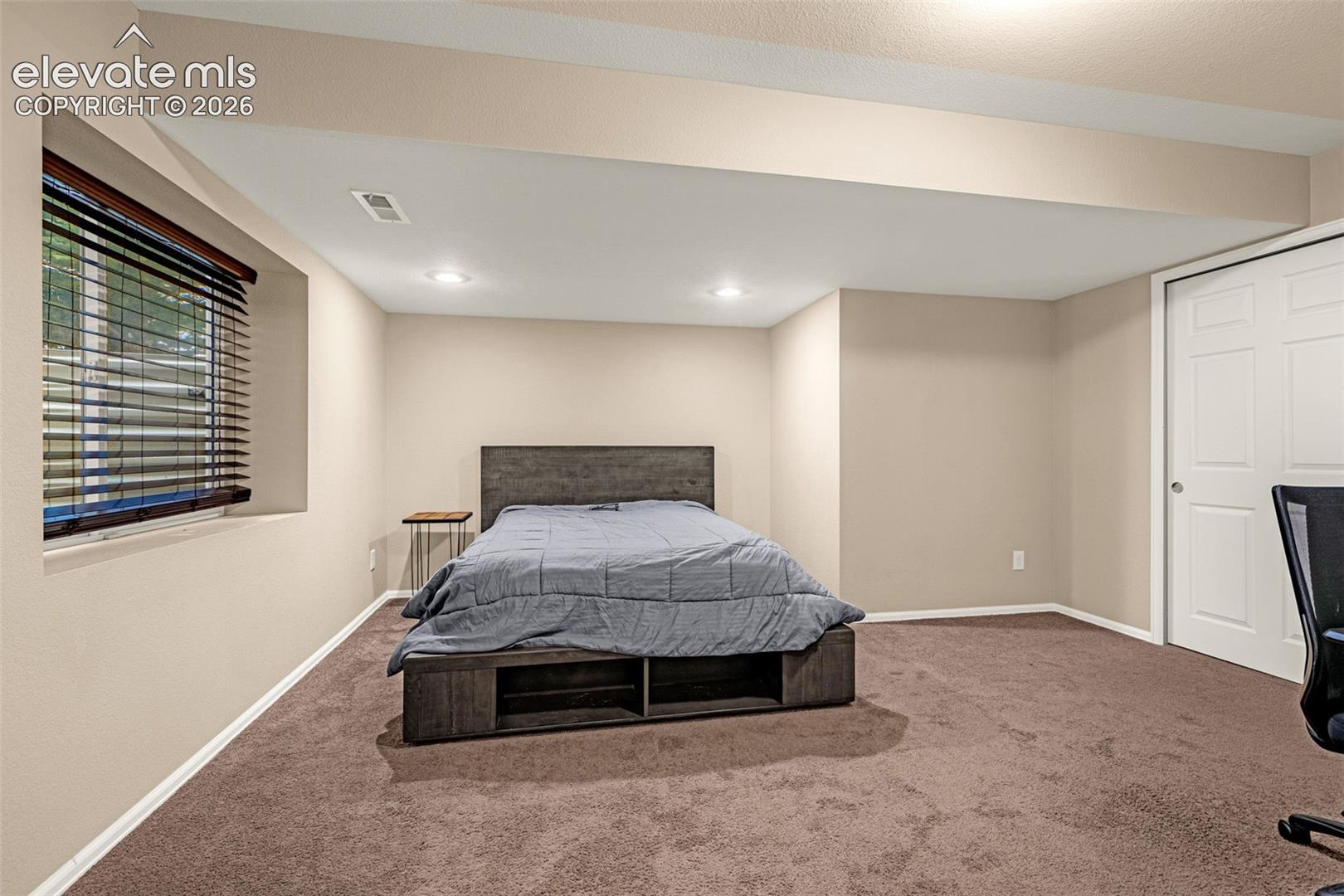 Recessed lighting, neutral wall paint, and brown carpet flooring