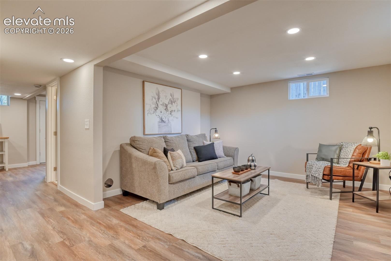 Recessed lighting, wood-finish flooring, and light neutral wall colors