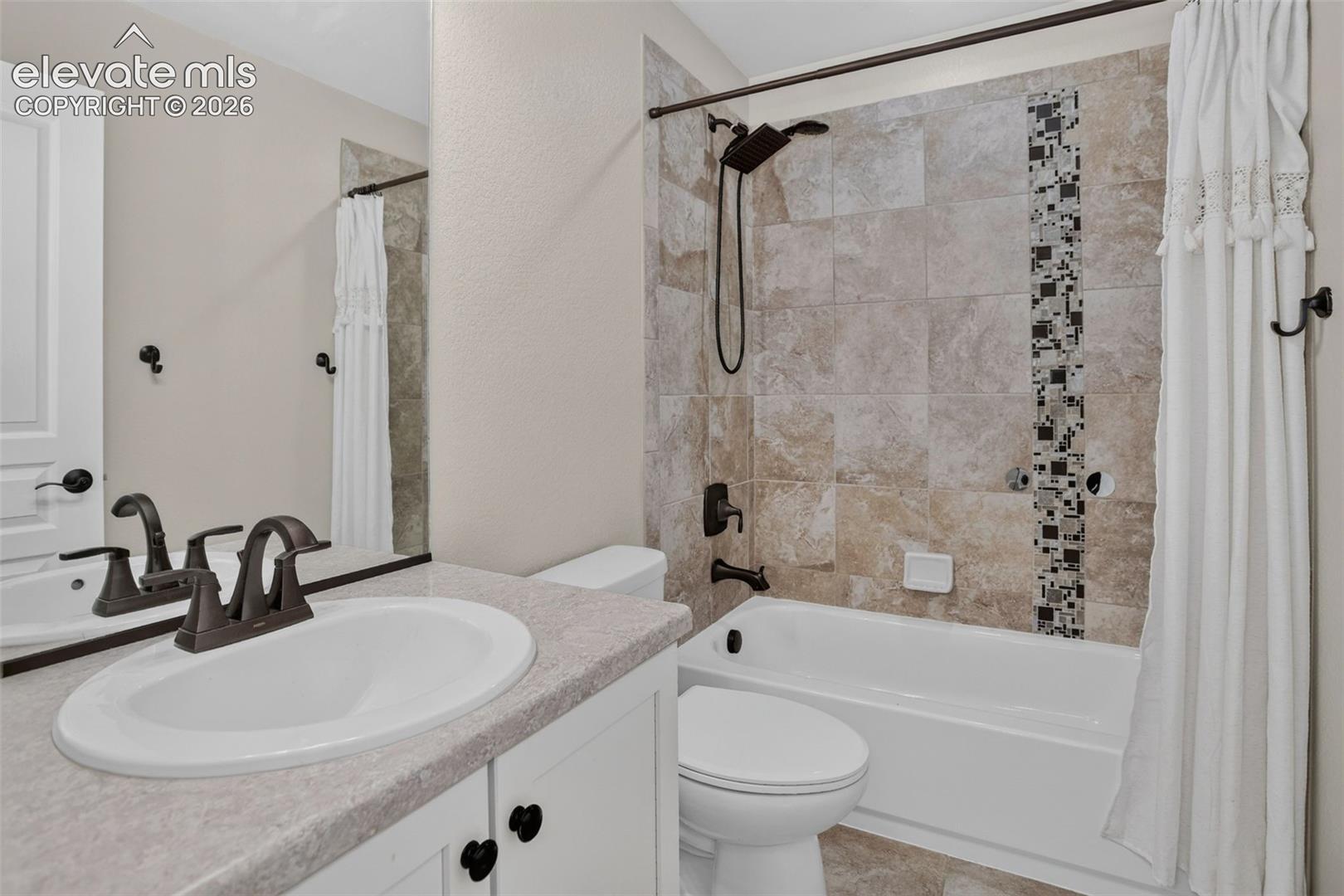 Built-in vanity with a single basin sink, counterspace, and white cabinetry