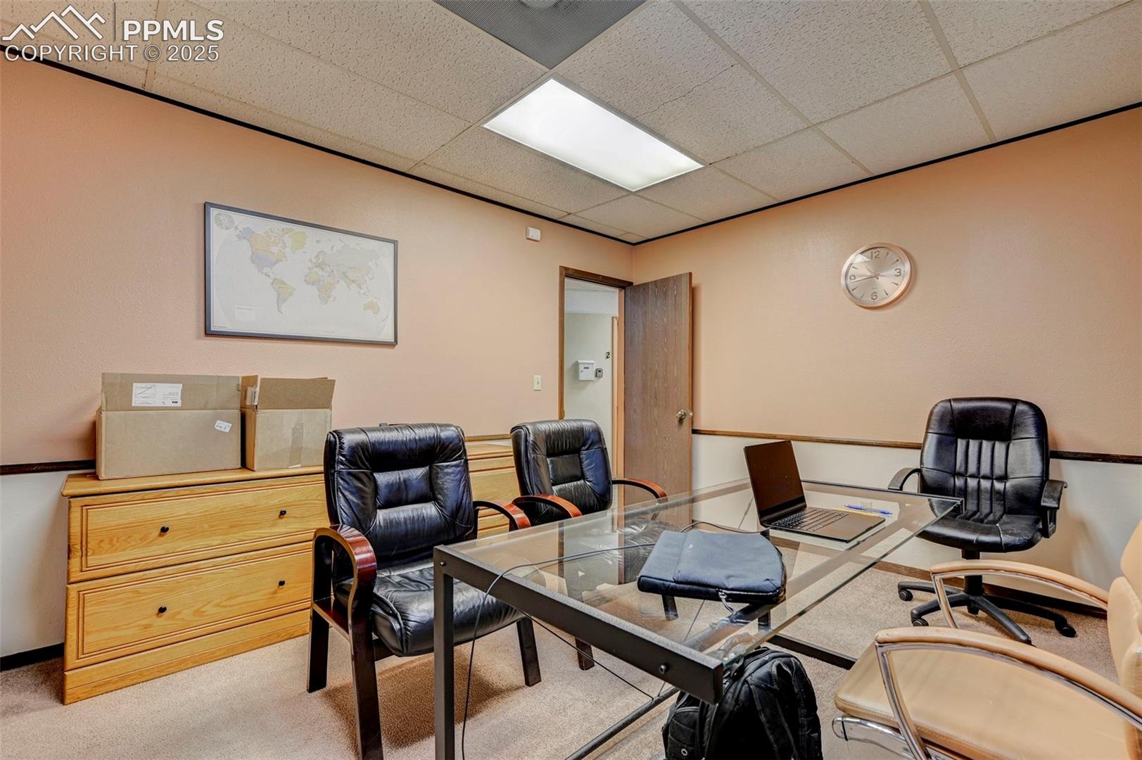 Carpeted office featuring a drop ceiling