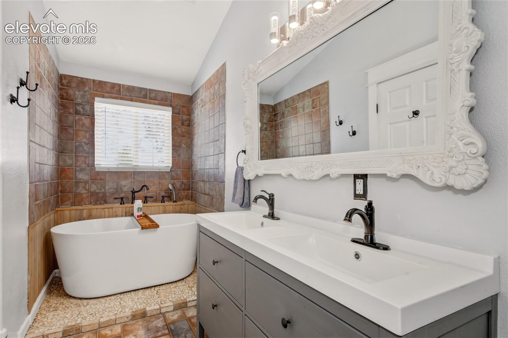Double vanity featuring a white rectangular countertop, dark grey cabinetry, and two dark-finish faucets
