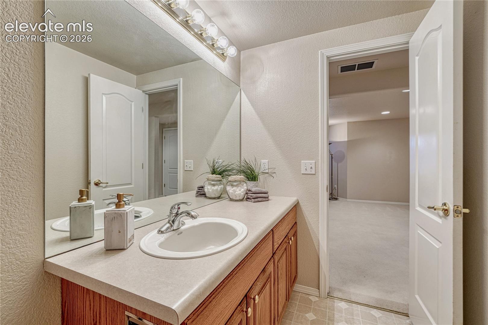 Well-maintained basement bathroom with bright vanity lighting and easy accessibility from the family room

