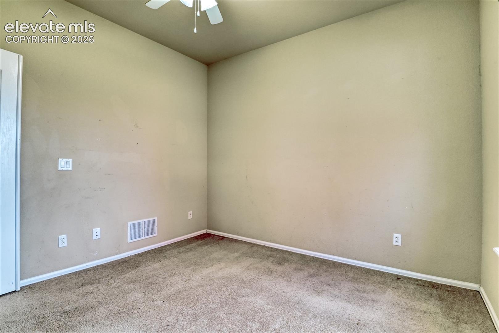 Room featuring neutral wall tones, plush wall-to-wall carpeting, and a ceiling-mounted fan with integrated light fixture