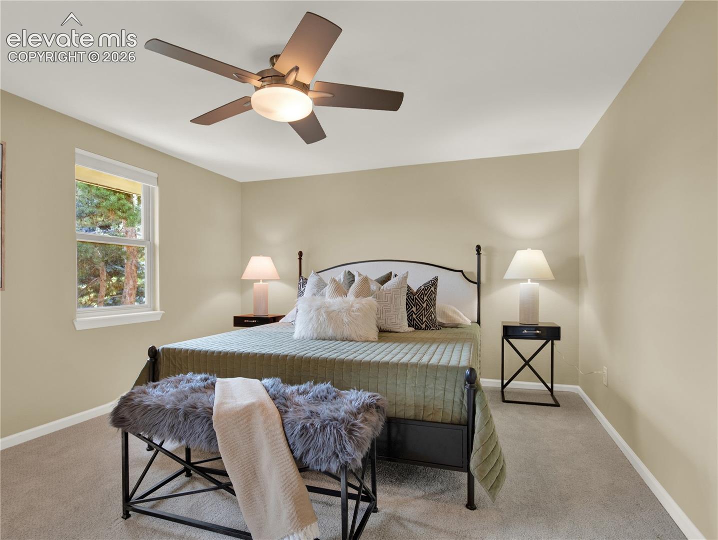 Neutral-toned walls, plush wall-to-wall carpeting, and a five-blade ceiling fan with integrated lighting