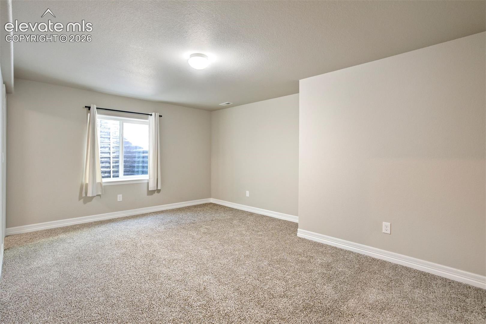 Recessed window with white trim, light-toned walls, neutral carpeting, and overhead lighting