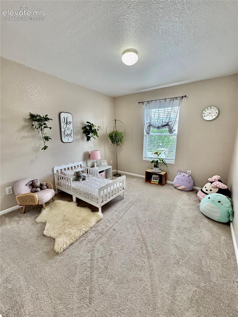 Bright room featuring a window with blinds, a flush mount ceiling light, and wall-to-wall carpeting