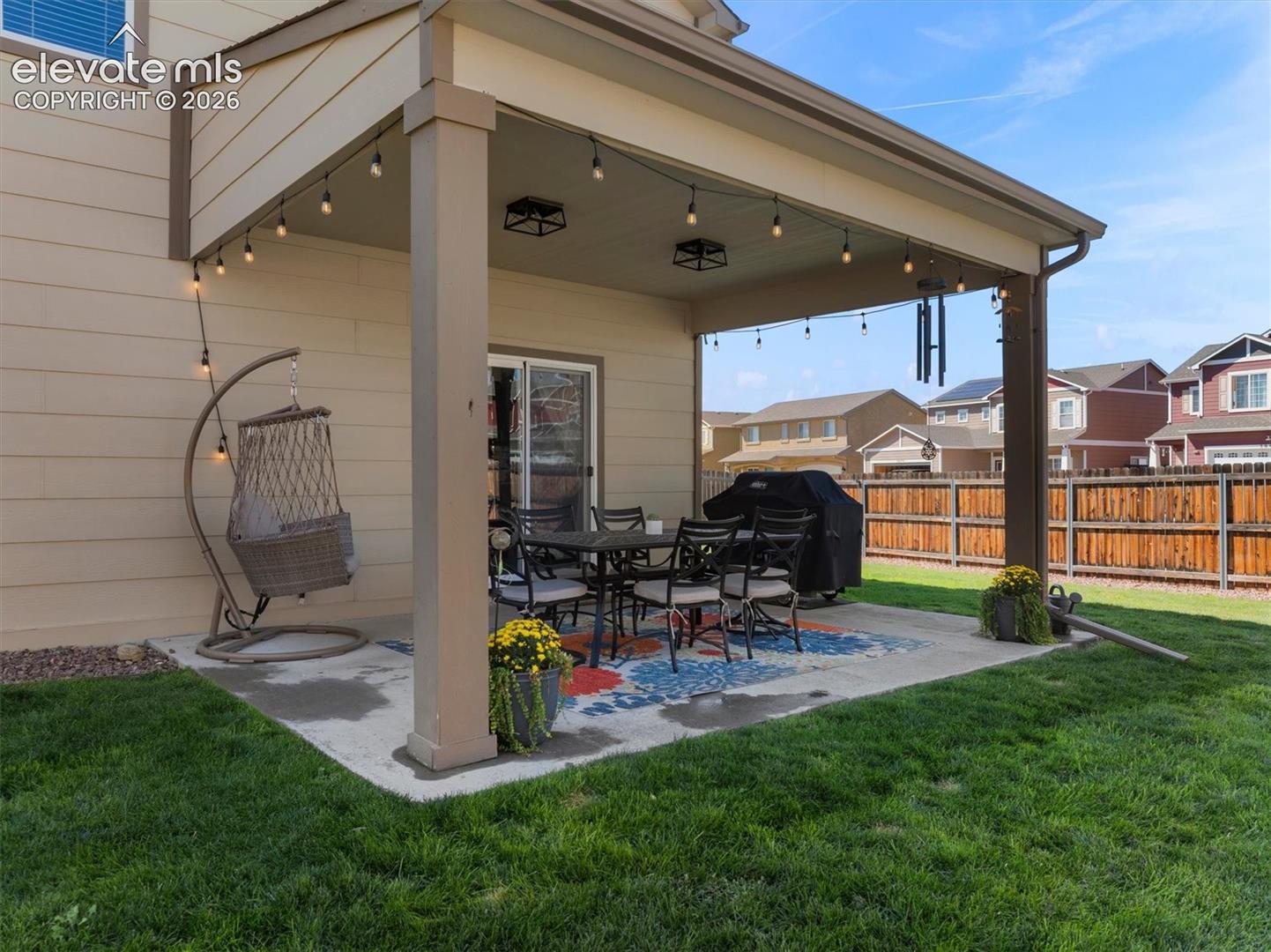 Expansive concrete patio with a covered   outdoor area and direct access to the interior via a sliding glass door