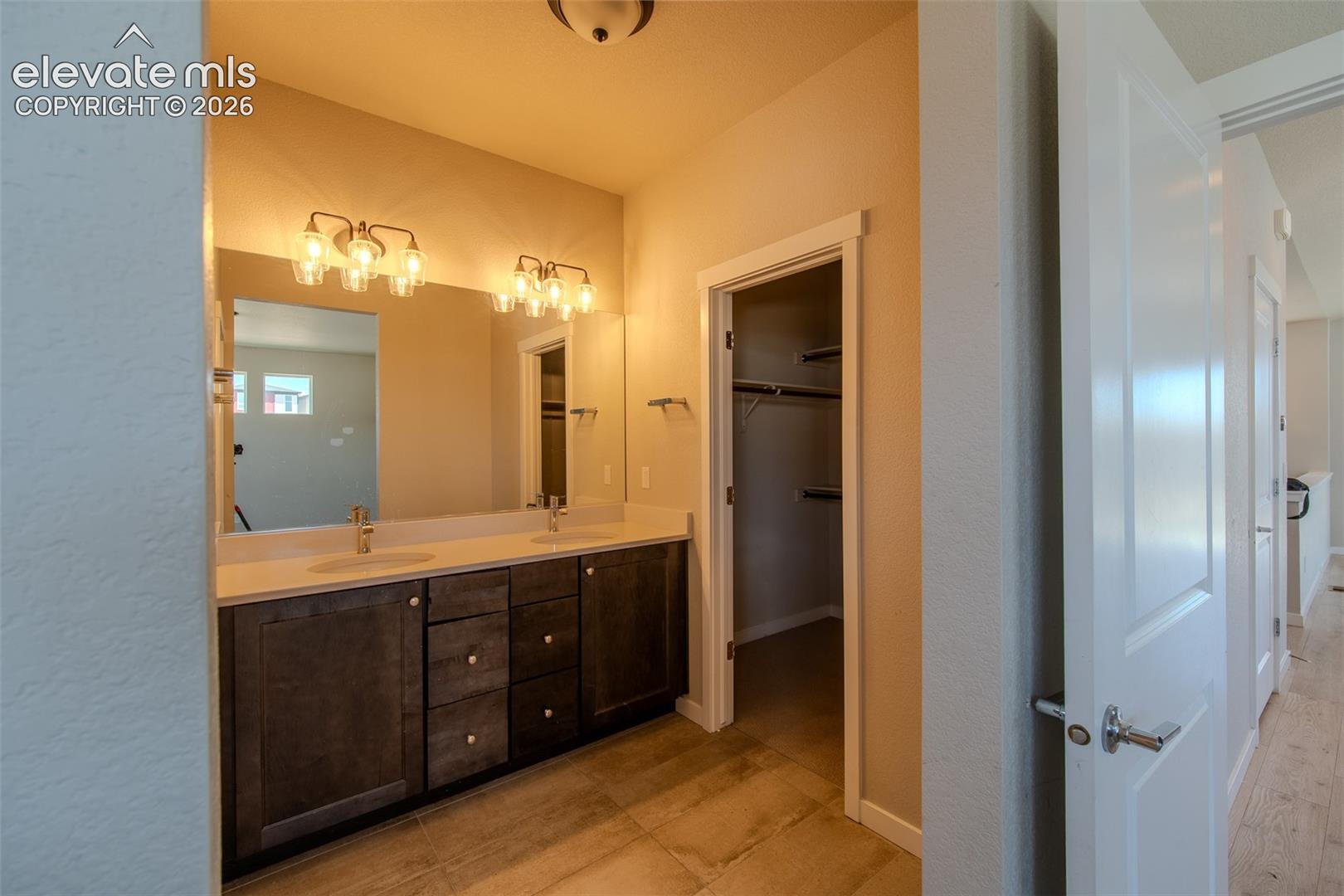 The Primary Bathroom has a dual sink vanity, mirror, and tiled shower.