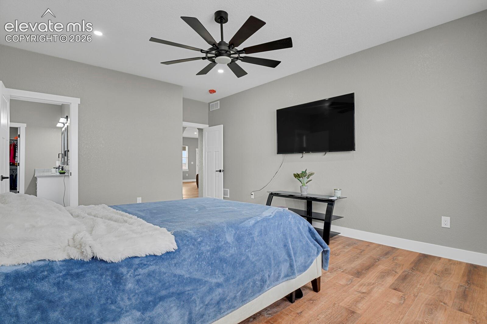 Wood-finish flooring, recessed lighting, and a ceiling fan with integrated lighting