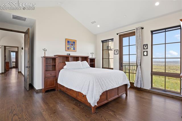 Main-level guest suite with Juliet balcony, vaulted ceiling, and private ensuite.