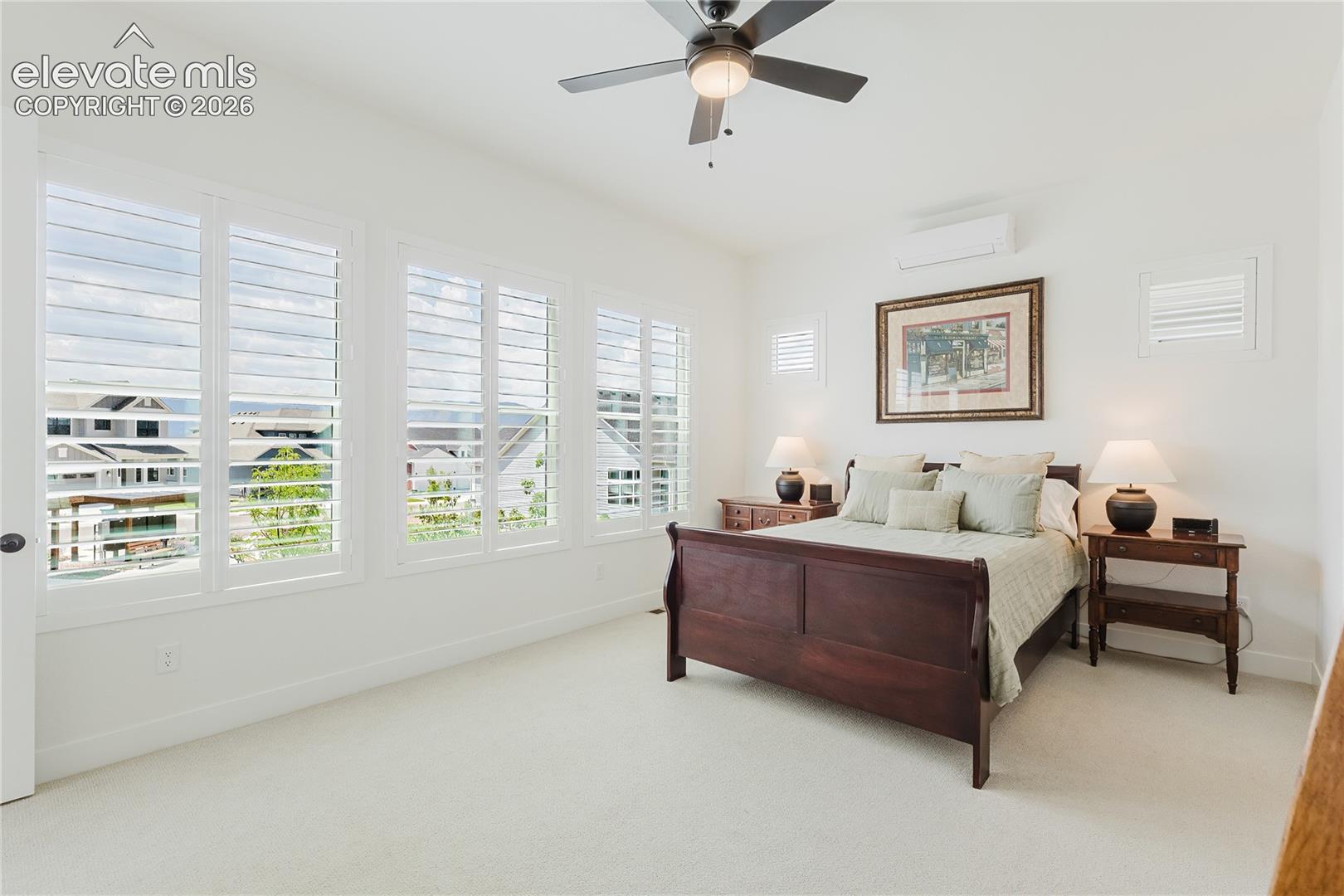Wall-to-wall carpeting with multiple windows featuring plantation shutters and views of trhe front range from the bed.  Dedicated mini split for extra AC