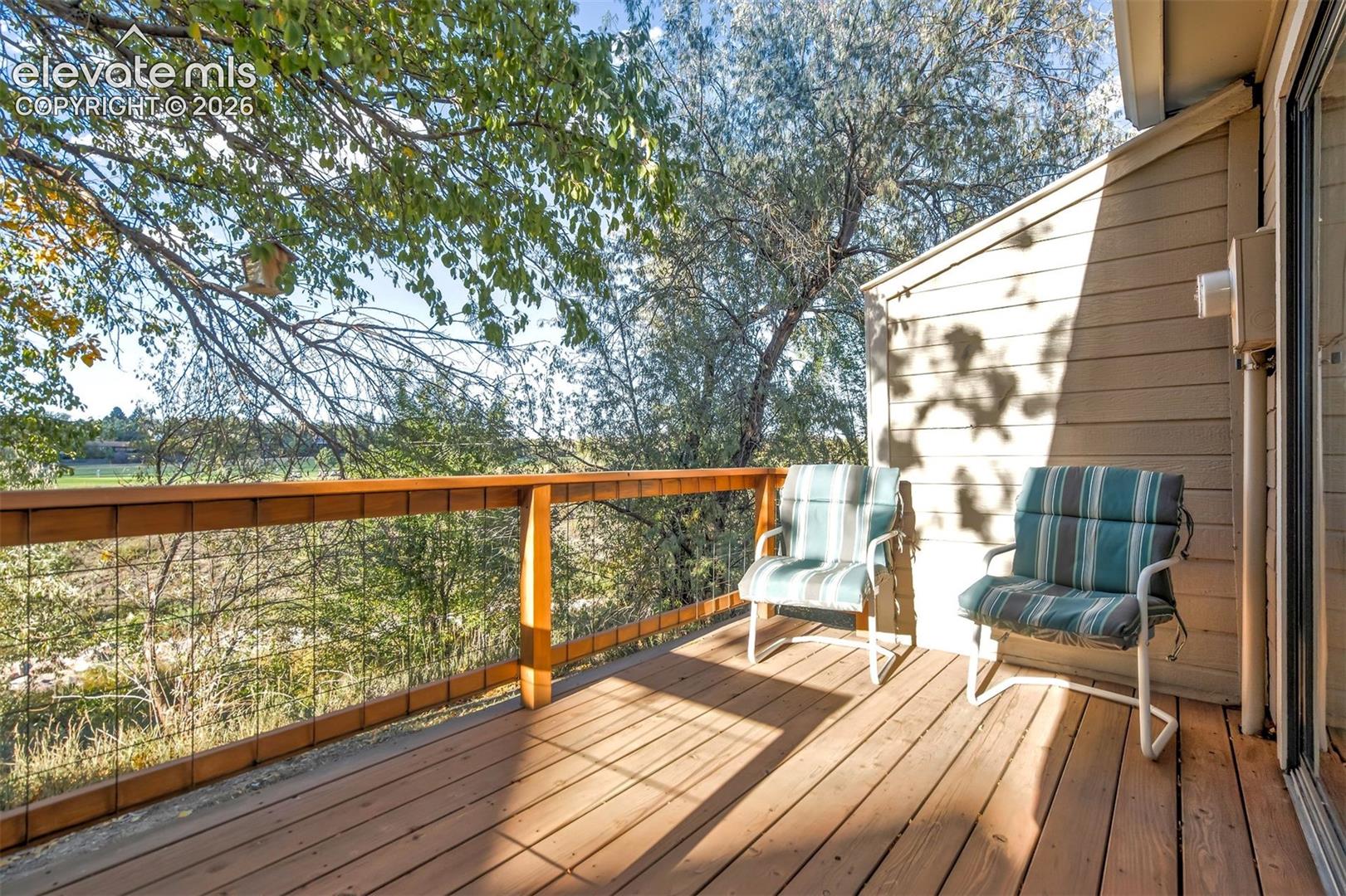 Elevated wood-plank deck featuring horizontal wood railing with wire tension infill and horizontal lap siding