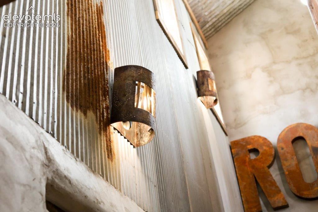 Corrugated metal wall with integrated sconce lighting and decorative metal lettering