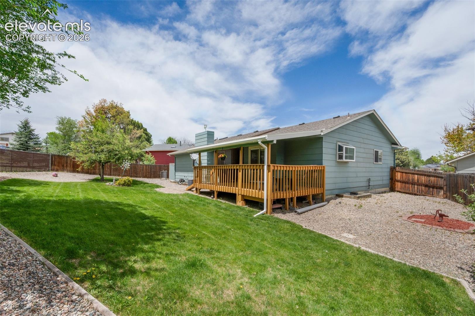 Rear view of property featuring a wooden deck and a chimney