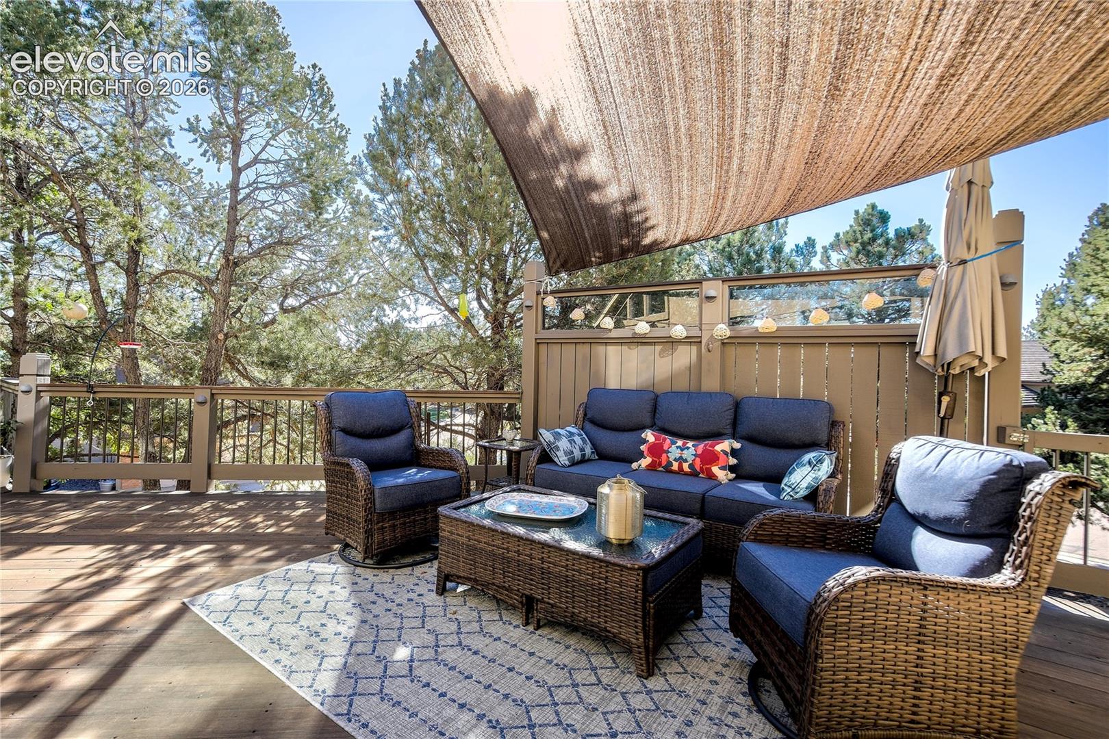 An expansive Brazilian Ipe deck creates an outdoor room beneath the pines, complete with sunshade + privacy wall.