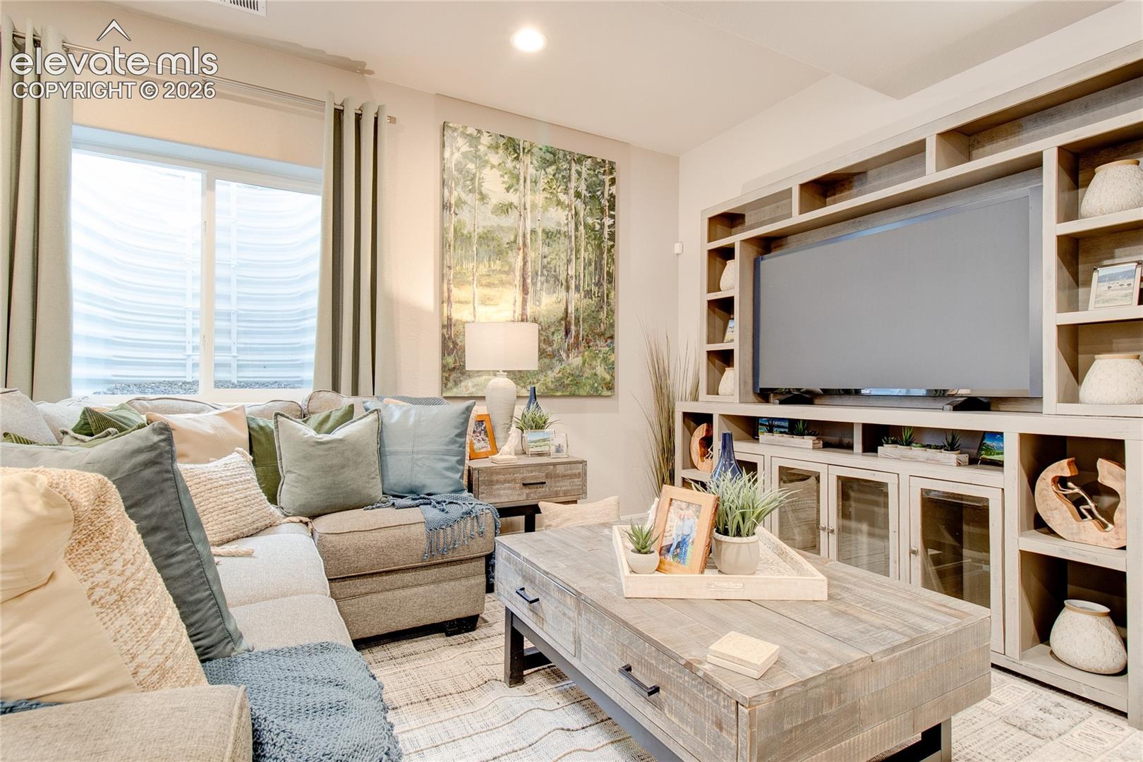Built-in floor-to-ceiling media cabinetry featuring open shelving and glass-front lower storage