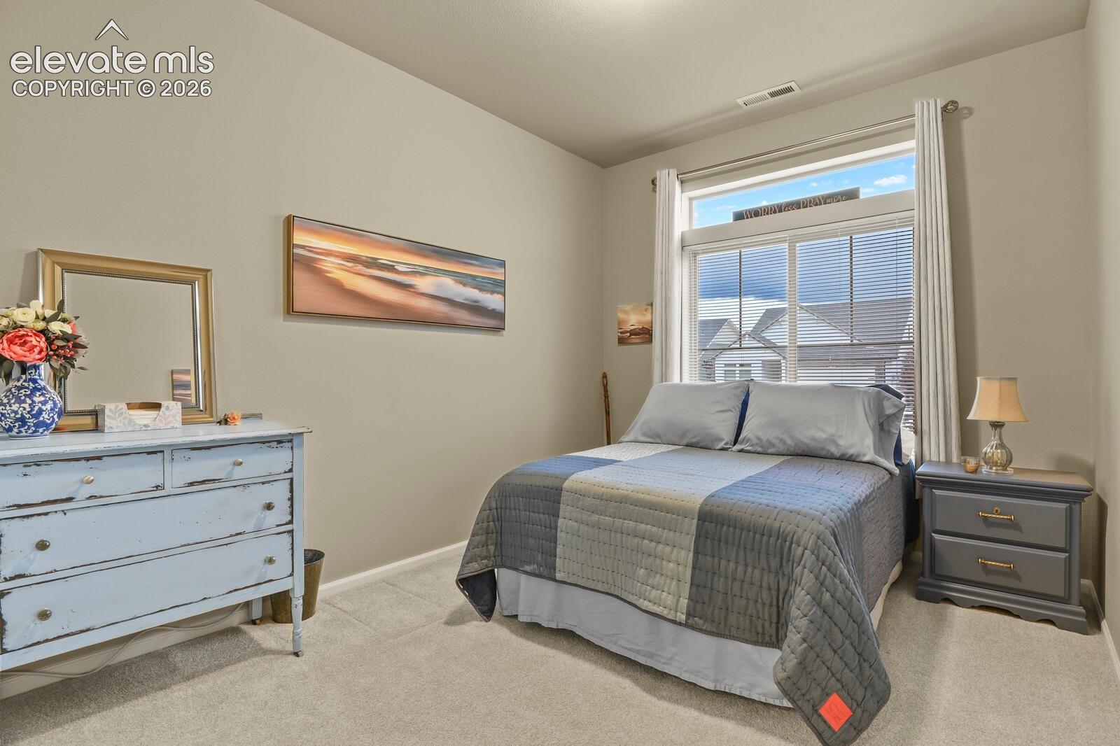 Neutral-toned walls with carpeted flooring and a large window featuring an integrated transom
