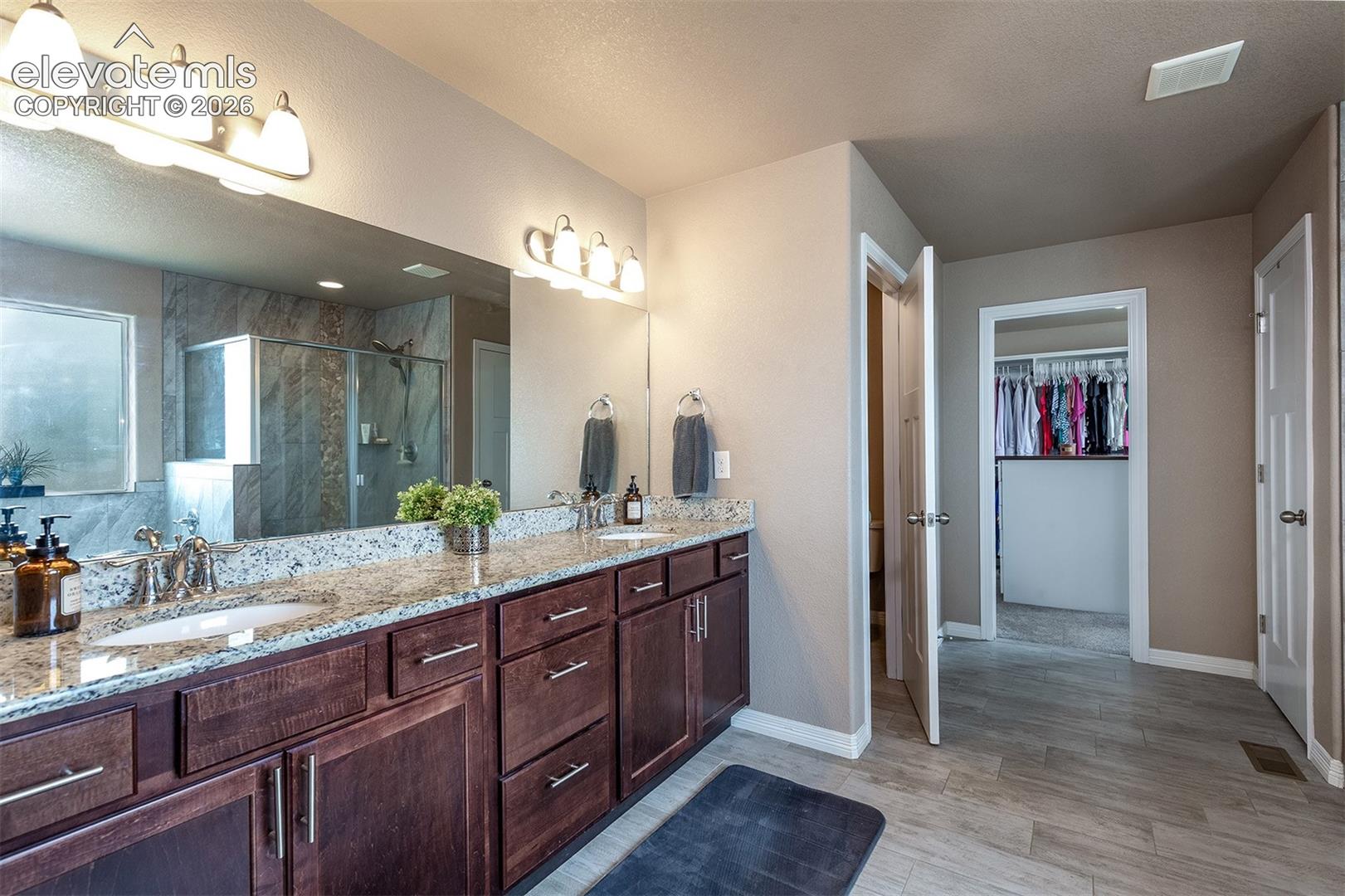 Spacious primary 5-piece bath with an oversized double vanity, walk-in shower, soaking tub, and walk-in closet