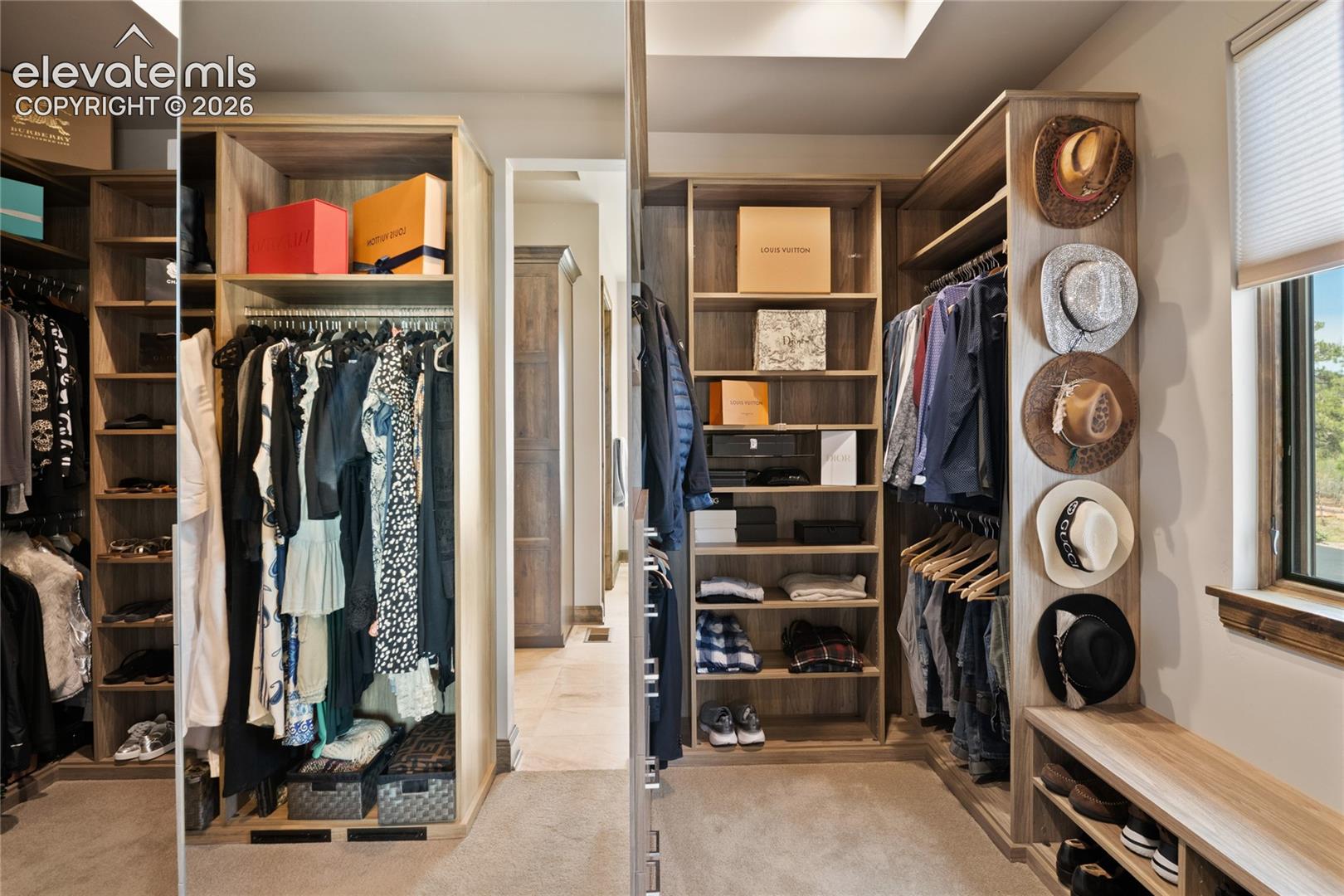 Designed for a curated collection. Bespoke walk-in dressing room with full-height built-ins, dual hanging zones, integrated shoe and accessory storage, and a dedicated dressing area lit by natural light.