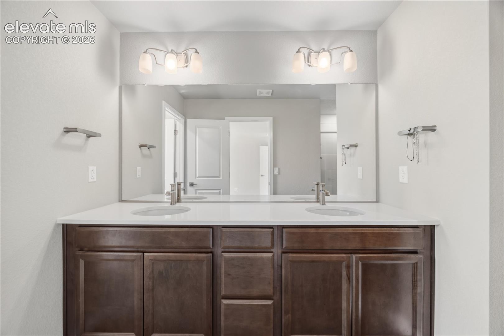 Upper Level Primary Bathroom with a comfort height, dual sink vanity and mirror.