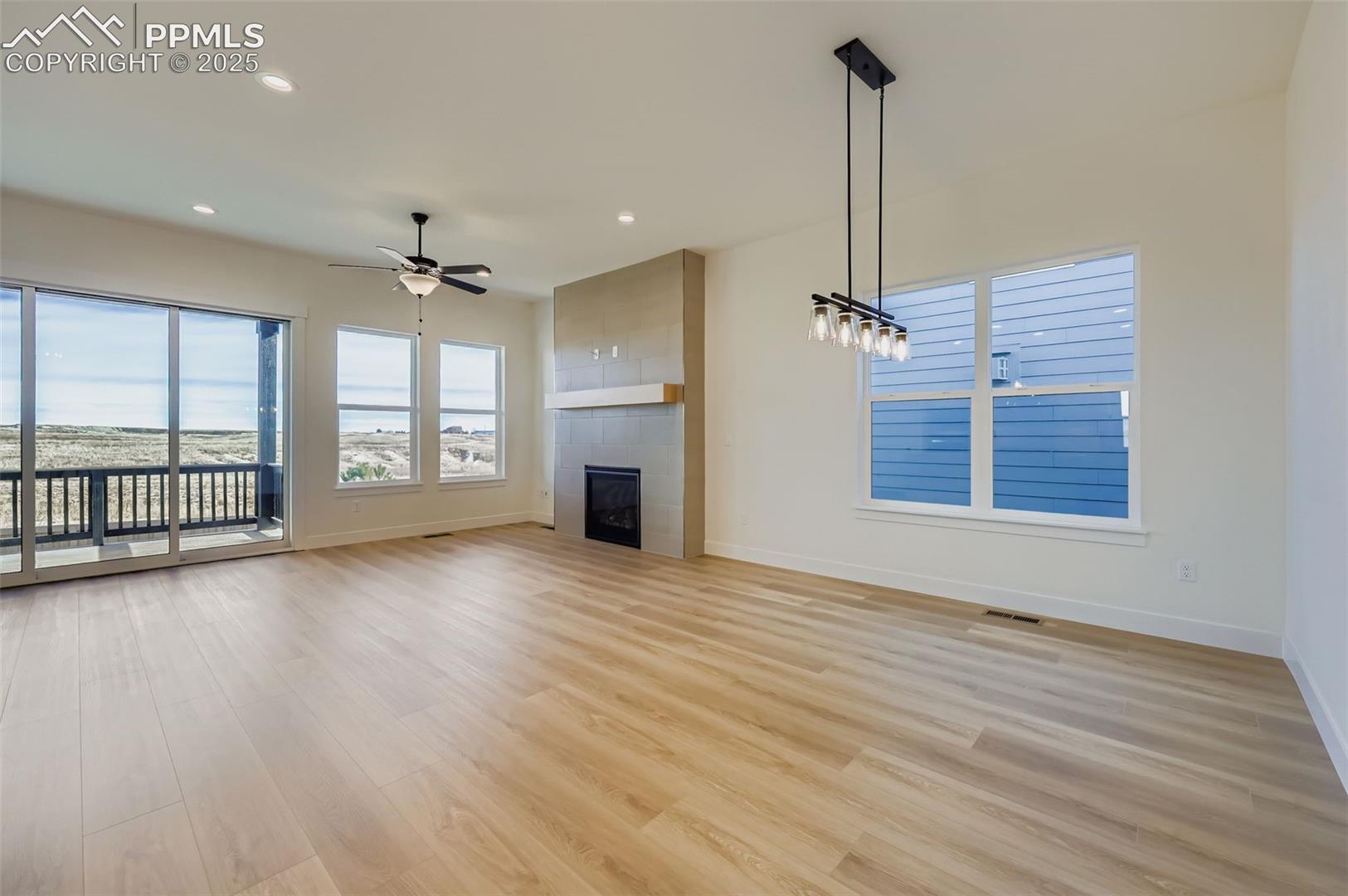 Unfurnished living room with recessed lighting, a fireplace, light wood-style floors, healthy amount of natural light, and ceiling fan