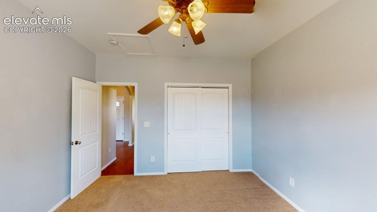 Ceiling fan with light kit, neutral wall paint, carpet flooring, and white paneled doors