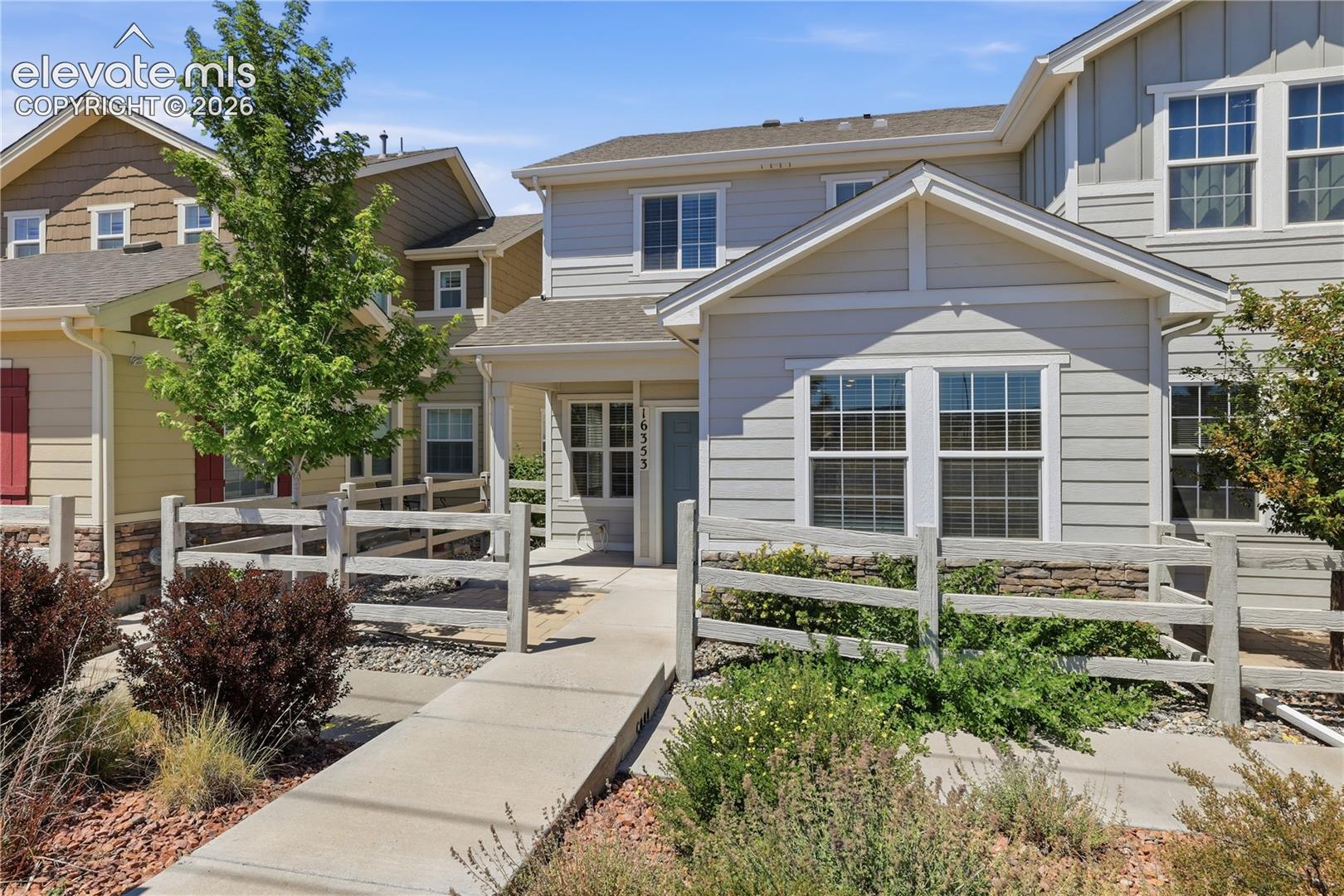 Two-story townhome featuring light gray horizontal siding and white trim