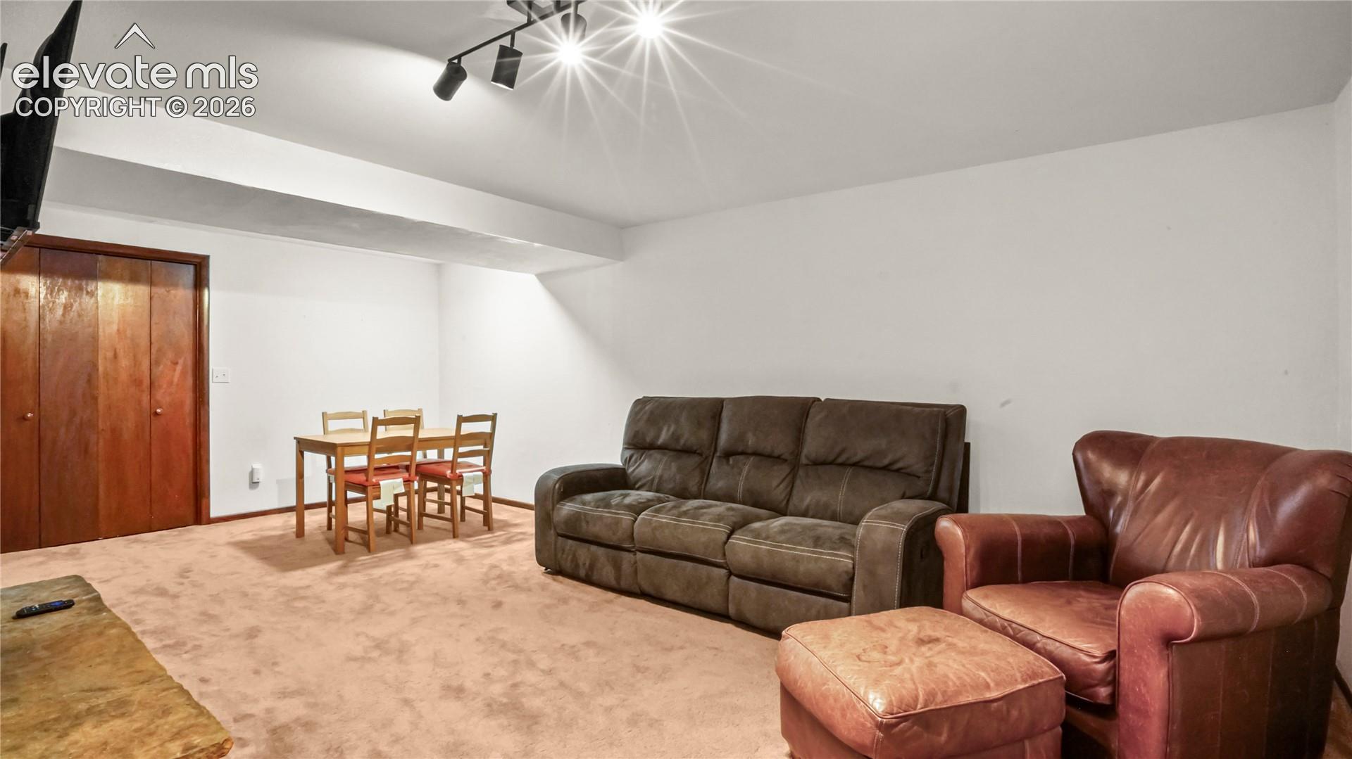Recessed track lighting and wall-mounted television, carpet