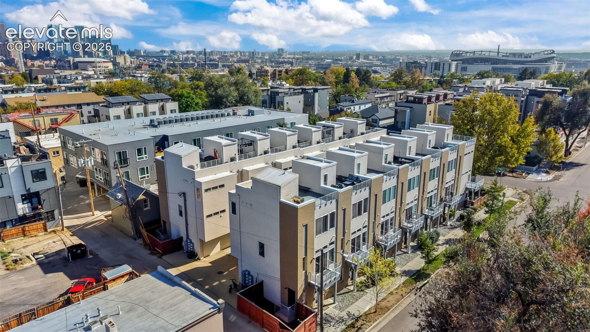 Multi-level residential complex featuring a contemporary facade, flat roof lines, private balconies with metal railings, and integrated surface parking