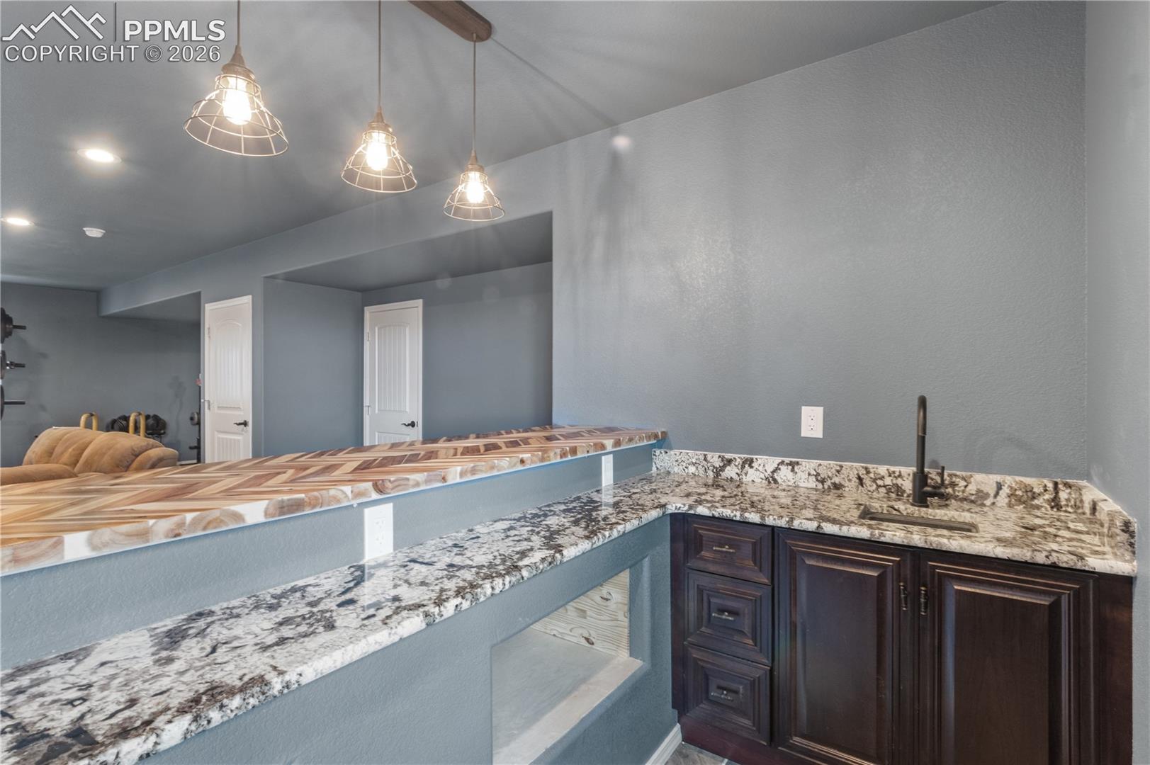 Kitchenette with space for a microwave, a bar sink, and recessed lighting