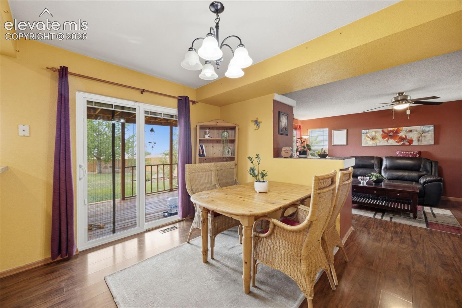 Dining area with wood-finish flooring and a multi-light chandelier