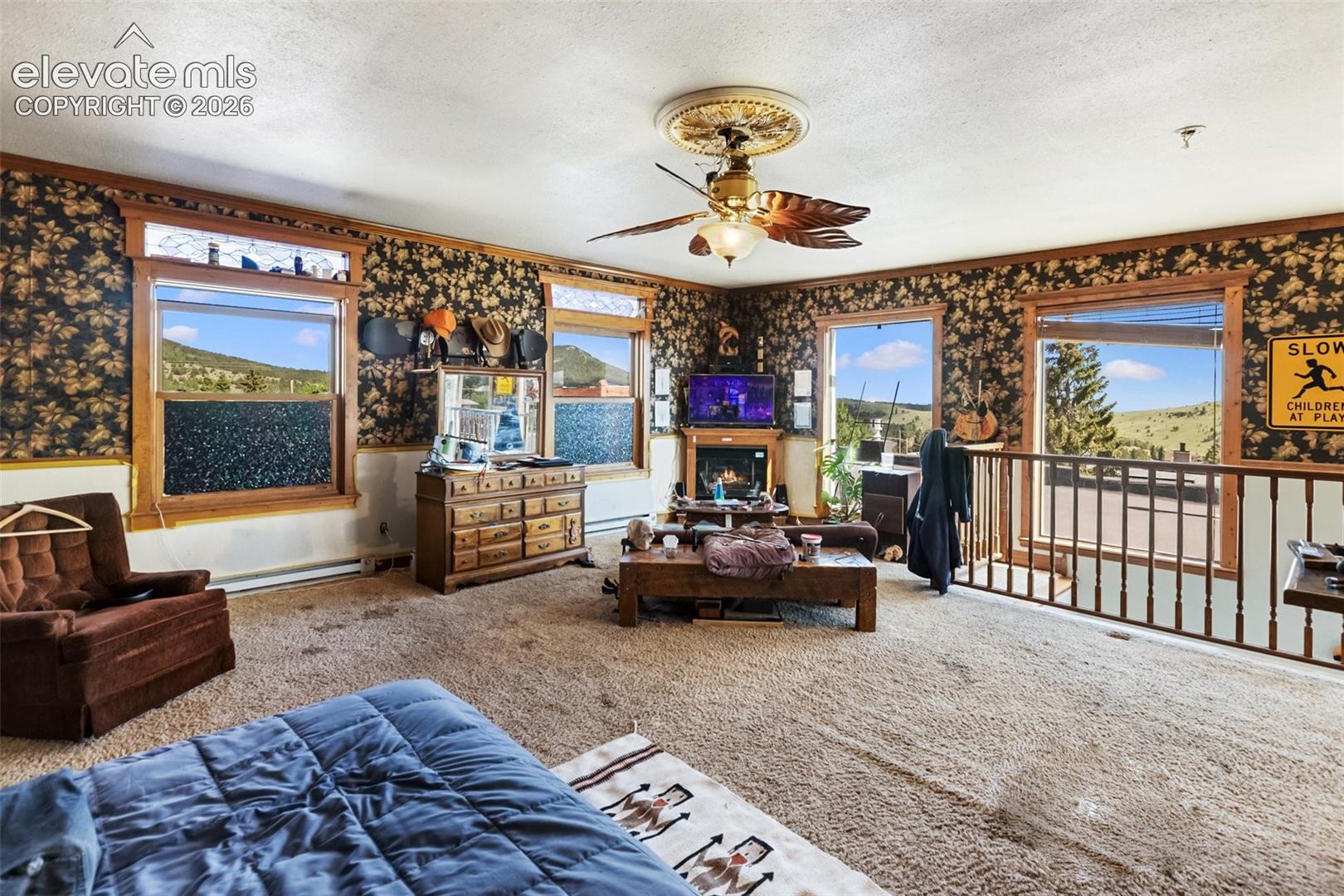 here is the very large upstairs bedroom, really a bedroom/living room combo with stove and great views out the windows to the mountain. The railing is along the stair case that provides access to this upper space